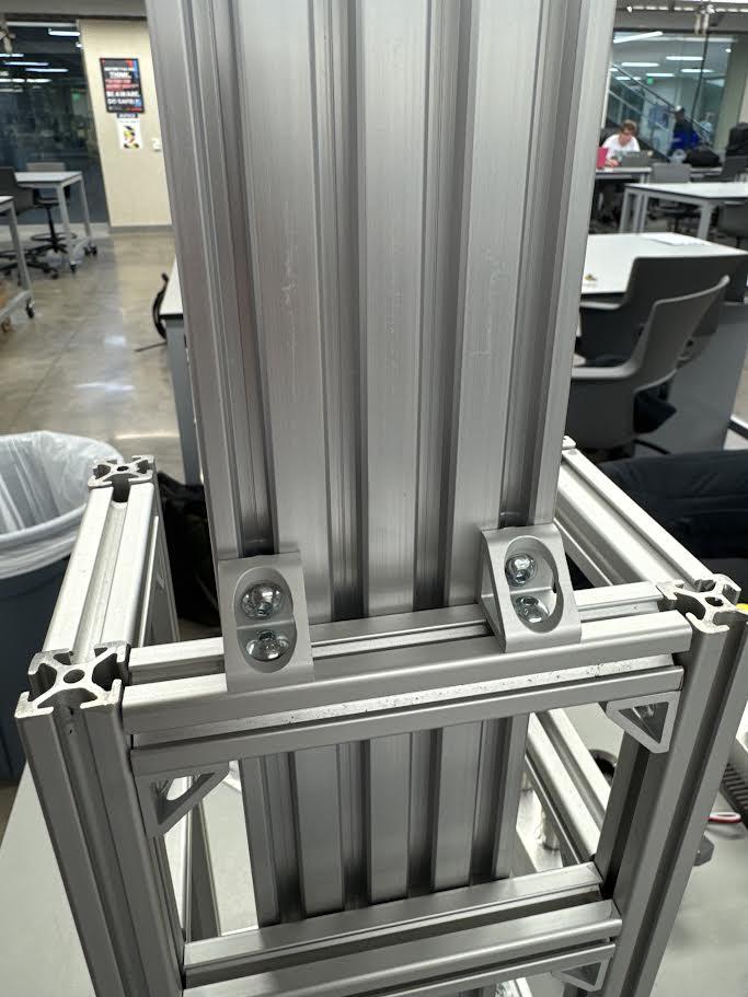 Photo of the 8020 aluminum frame corner, showing T-slotted gussets and assembled hardware.