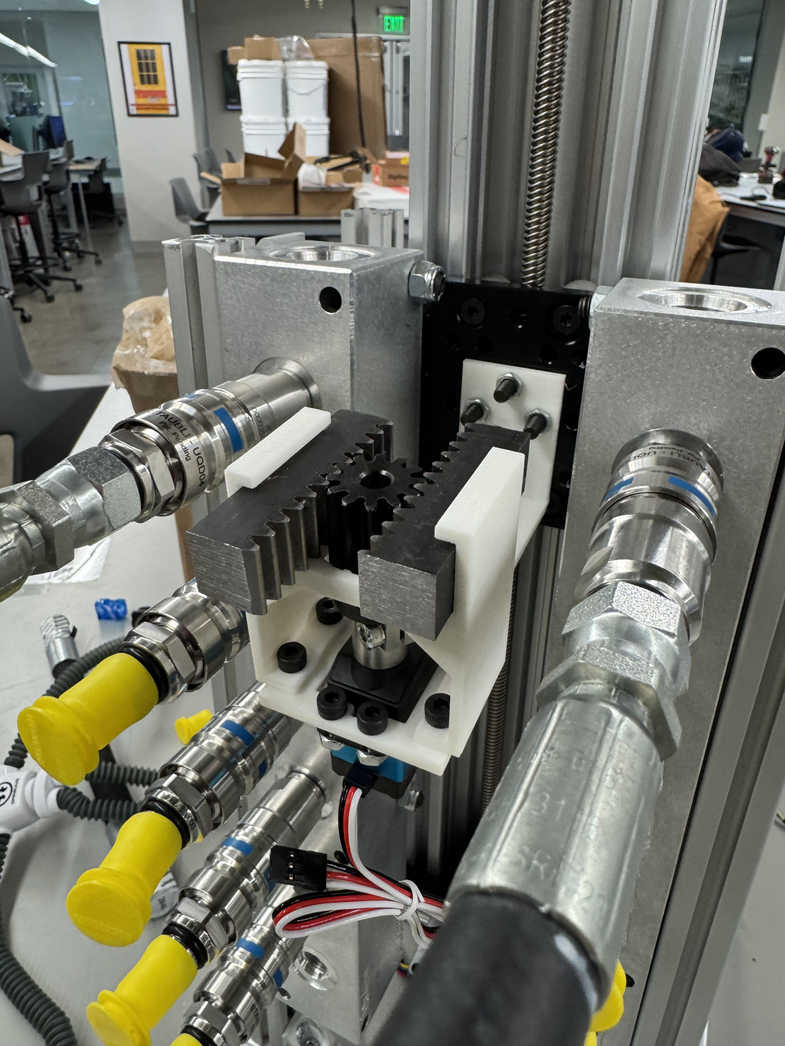 Close-up of the steel rack and 3D-printed pinion housing installed against the manifolds.